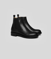 Vegan Chelsea boots - Woman in black leather, featuring handstitched details and a sleek design.