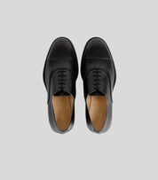 Vegan Oxford - Man stylish black formal shoes with rounded toe and front laces, top view.
