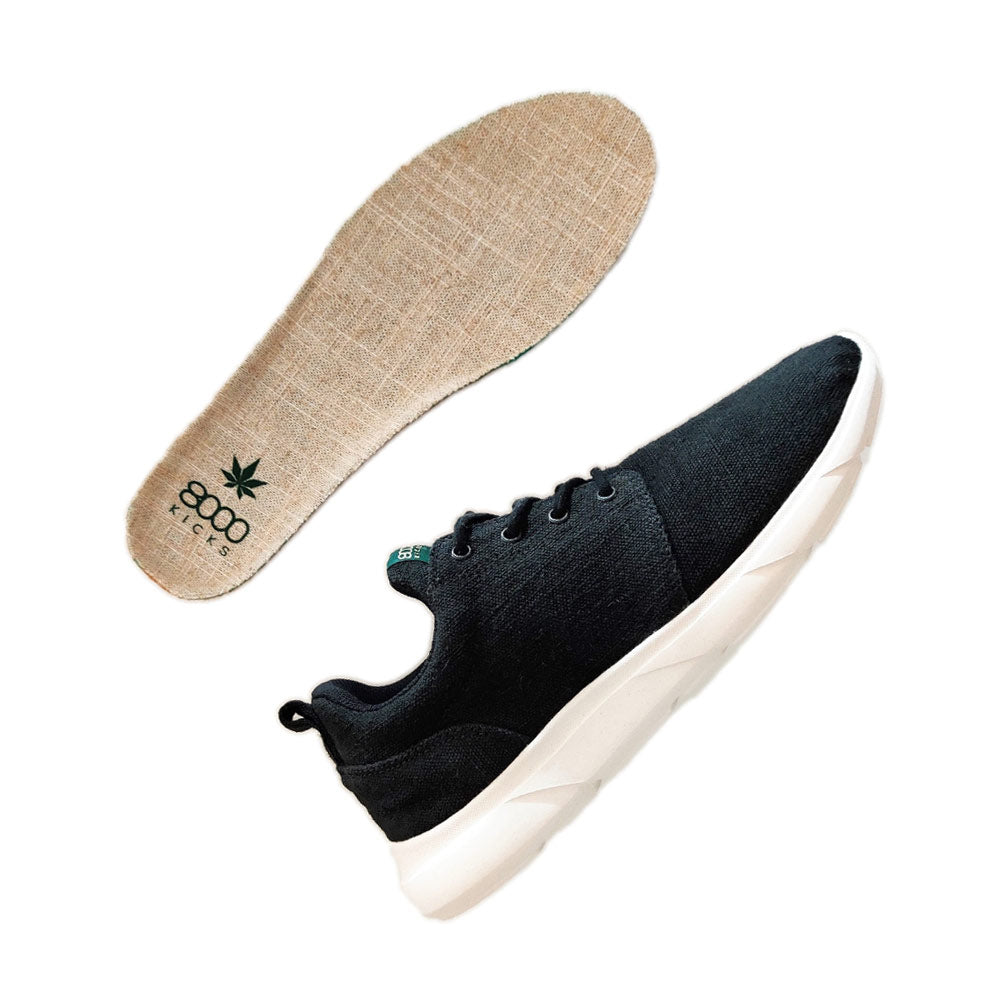 One 8000 Kicks Low Top Explorer V2 Black and White sneaker lying next to its removable hemp insole, highlighting the sustainable design of the shoe.