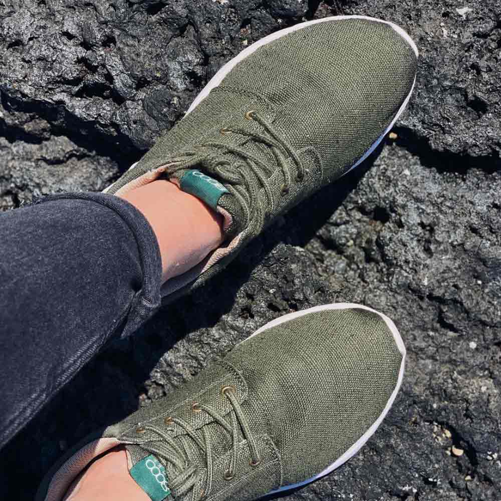 A close-up of the unisex 8000 Kicks Low Top Explorer V2 Green sneakers worn on rocky terrain, showcasing their durability and eco-friendly hemp material. Keywords: Hemp Sneakers, Hemp Shoes, Sustainable shoe.