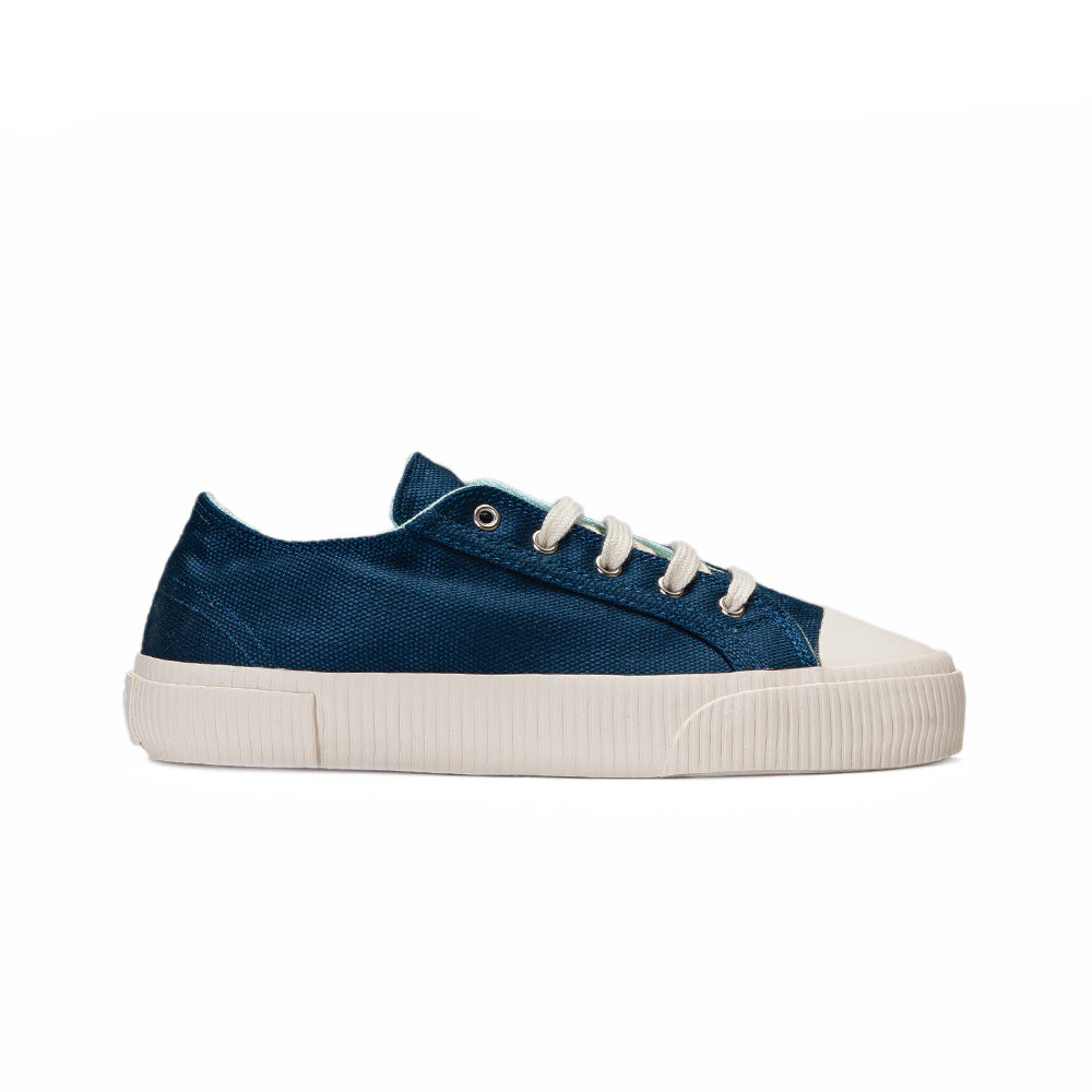 Side view of Bamburista Blue sneaker: A women's sneaker in blue bamboo textile, featuring white laces and a sustainable rubber sole. The shoe has a sleek design with subtle stitching.