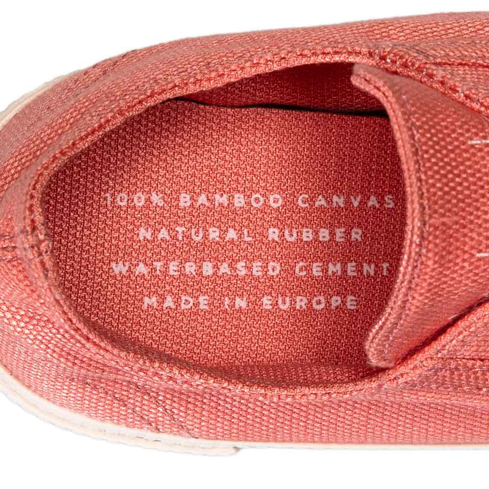 Close-up of the insole of a Bamburista Flamingo sneaker, displaying text: "100% Bamboo Canvas, Natural Rubber, Waterbased Cement, Made in Europe."