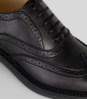 Vegan Oxford Brogue - Woman close-up showing broguing details and sleek black finish.