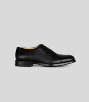 Vegan Oxford - Man side view of formal black shoes with rounded toe and laces, showcasing sophisticated style.