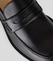 Vegan Loafer - Woman, close-up of black leather upper with distinctive U-shaped design.