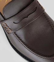 Vegan Loafer - Woman showing a close-up of the leather upper with distinctive U-shaped pattern.
