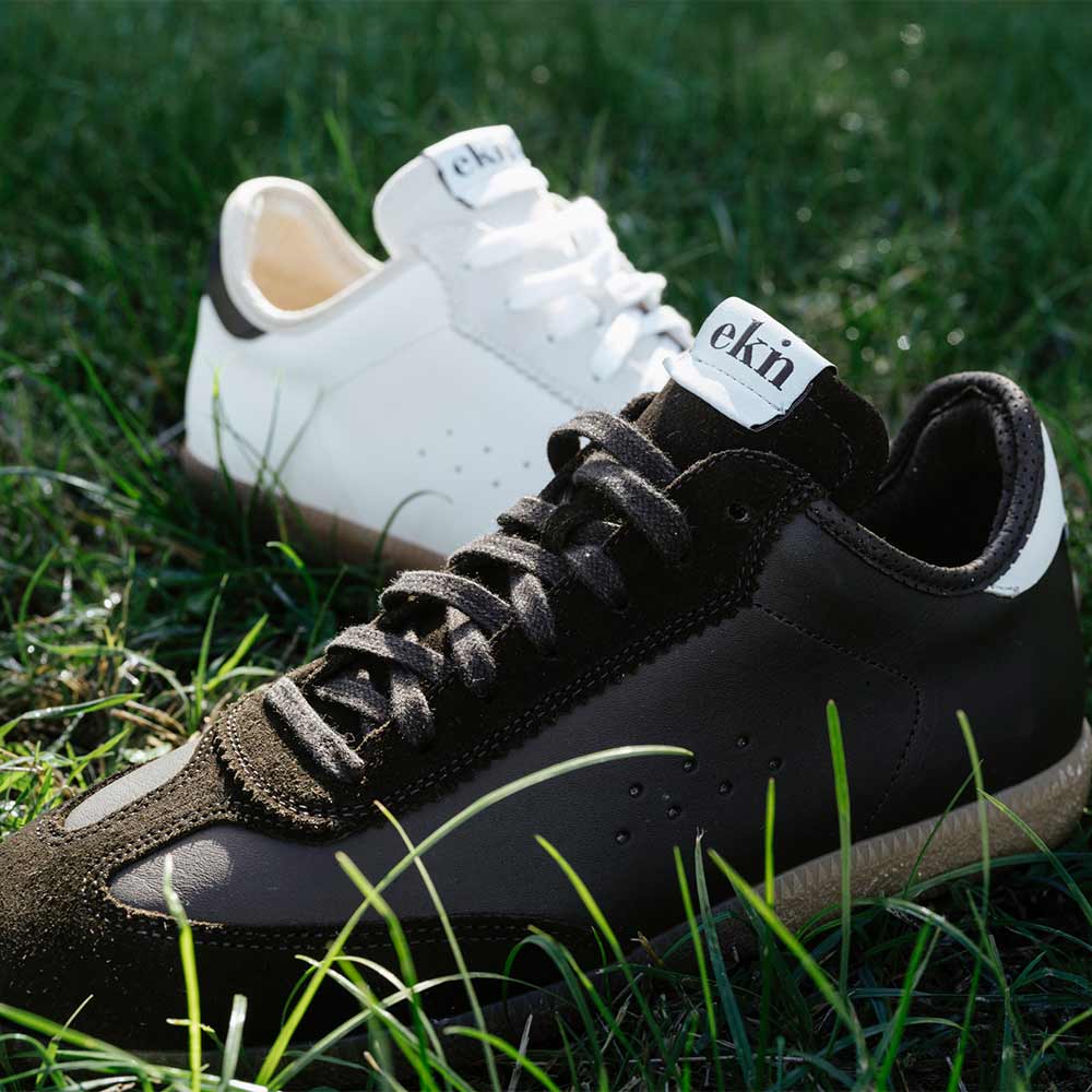 Tsuga Coal and another EKN shoe in the grass, highlighting shoes sustainable and eco-friendly design.