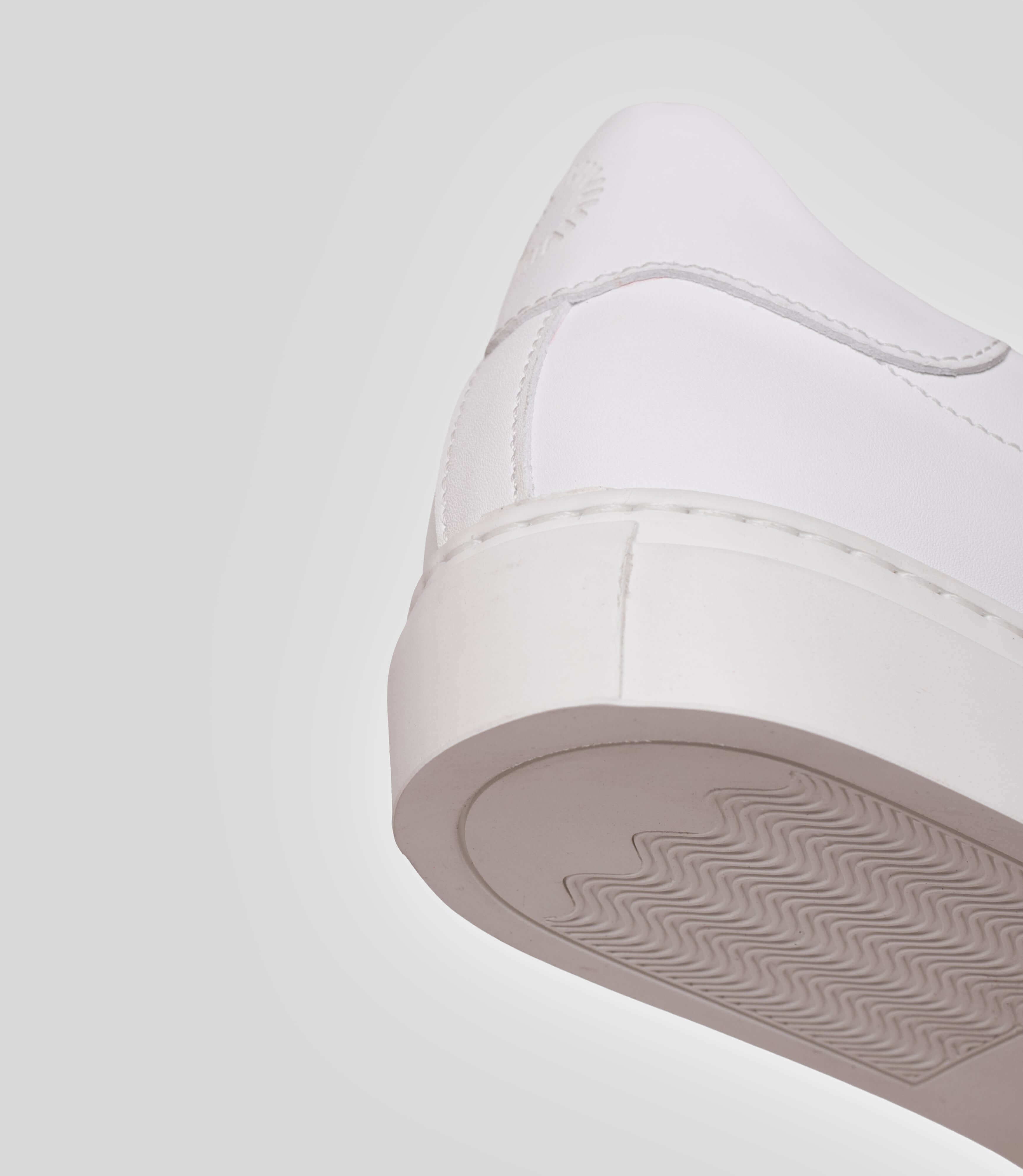 Vegan sneakers handmade in Italy, detail of the heel and sole of a white sneaker.
