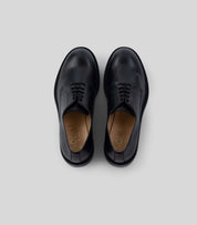 Vegan Derby - Woman in black leather, featuring an open lacing system, perfect for formal and casual events.